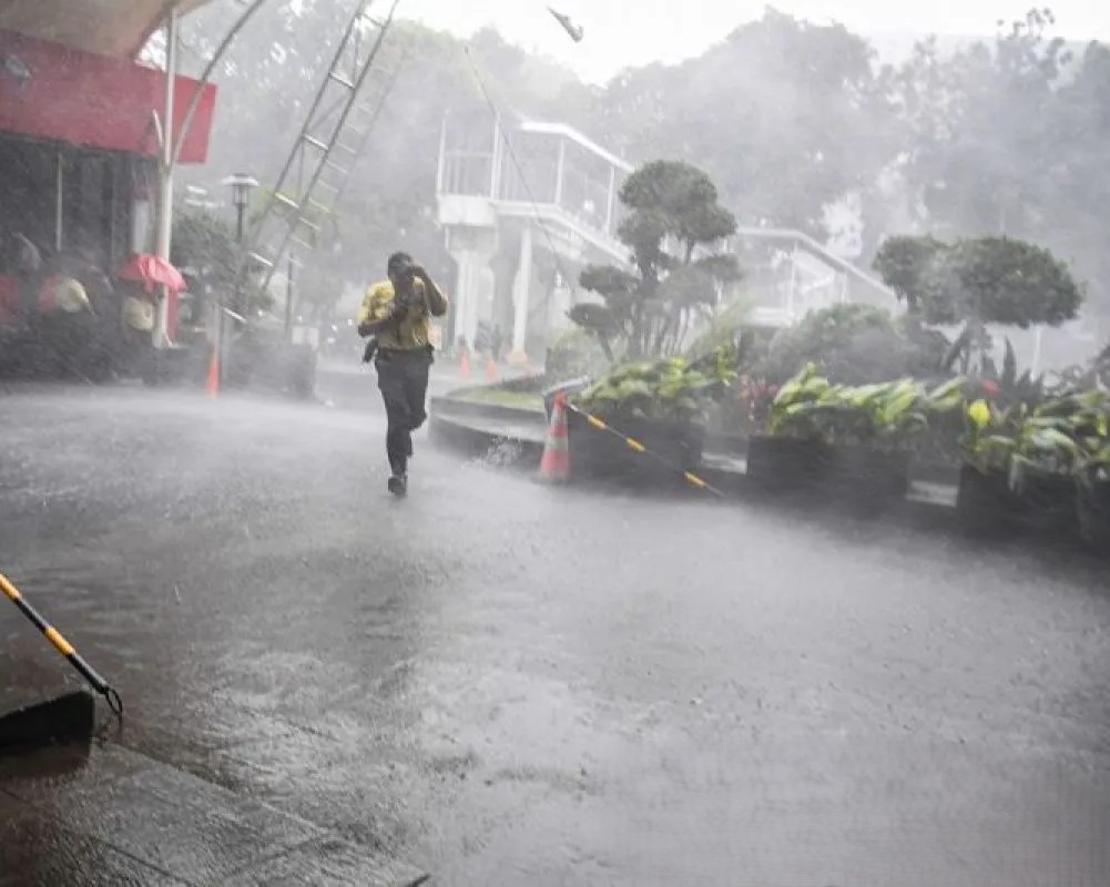 Masyarakat membawa payung saat hujan lebat melanda sejumlah kota di Indonesia